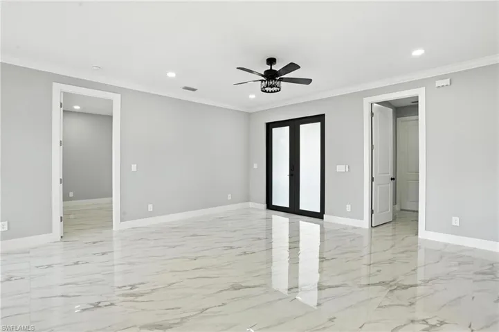 Empty room featuring light marble finish floors, recessed lighting, ceiling fan, and crown molding