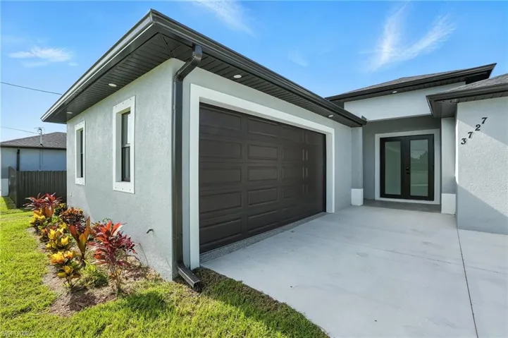Garage featuring french doors and concrete driveway