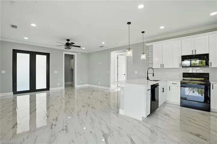Kitchen with black appliances, open shelves, a peninsula, light countertops, and light marble finish flooring