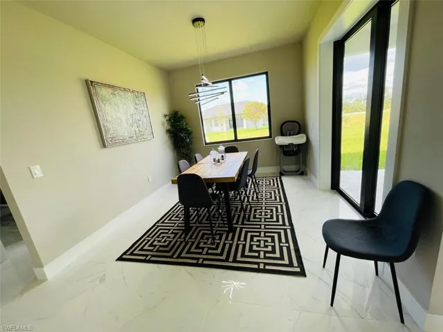 Dining area featuring light marble finish flooring and baseboards