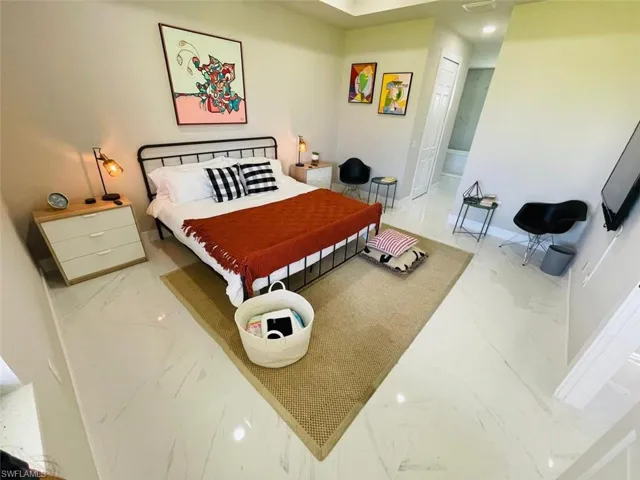 Bedroom with light marble finish floors, recessed lighting, and a closet