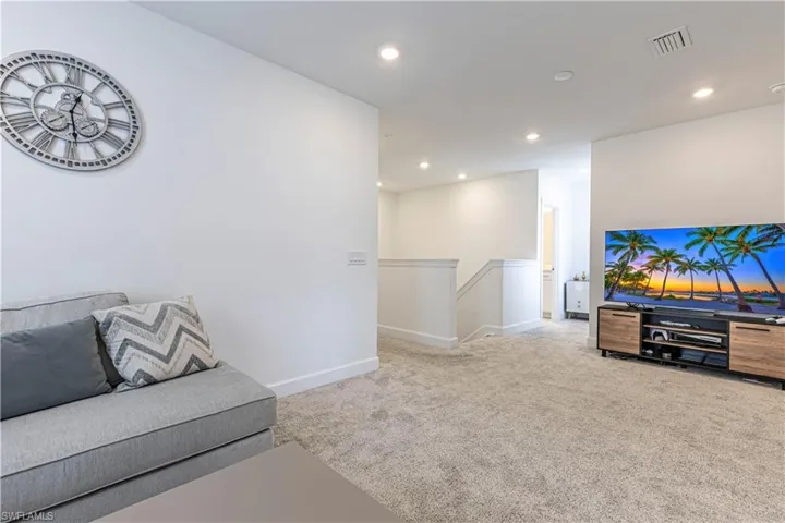 Unfurnished living room with carpet, baseboards, and recessed lighting