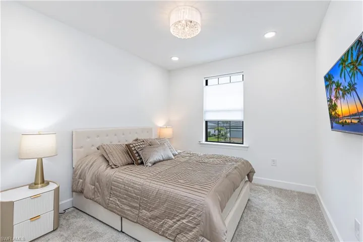 Carpeted bedroom with baseboards, recessed lighting, and a chandelier