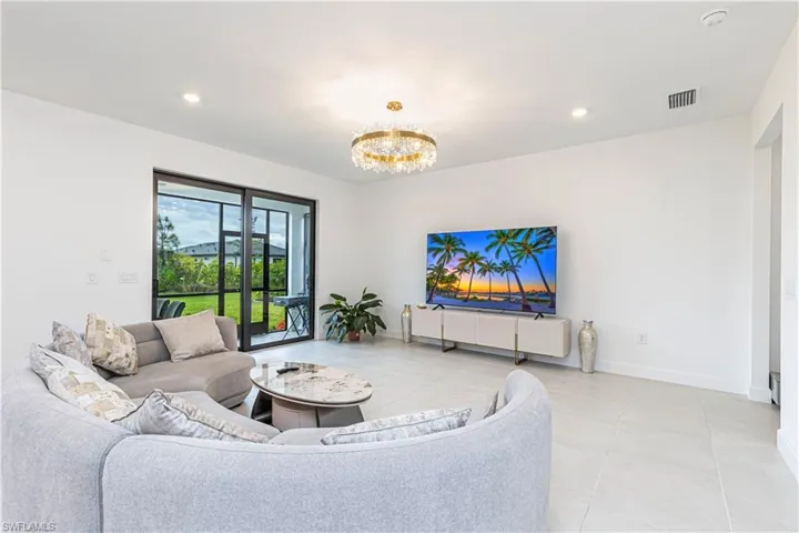 Living room featuring a chandelier, light tile patterned floors, baseboards, and recessed lighting