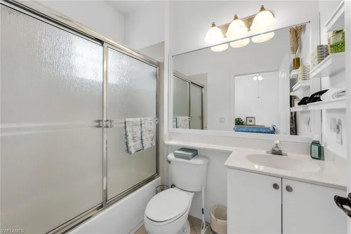 Ensuite bathroom with tub/shower combination and neutral finishes.