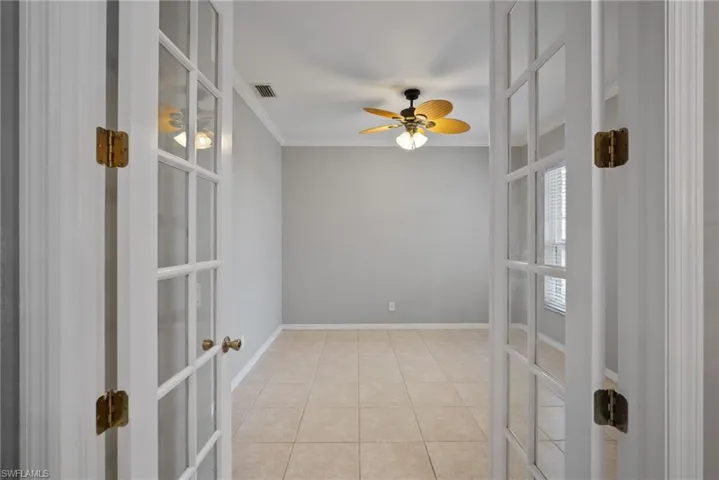 Unfurnished room with ceiling fan, crown molding, french doors, and tile patterned floors