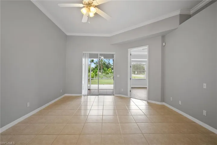 Spare room with ceiling fan, light tile patterned floors, and crown molding