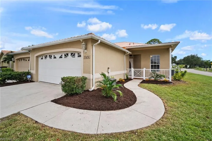 Ranch-style house with a garage and a front lawn