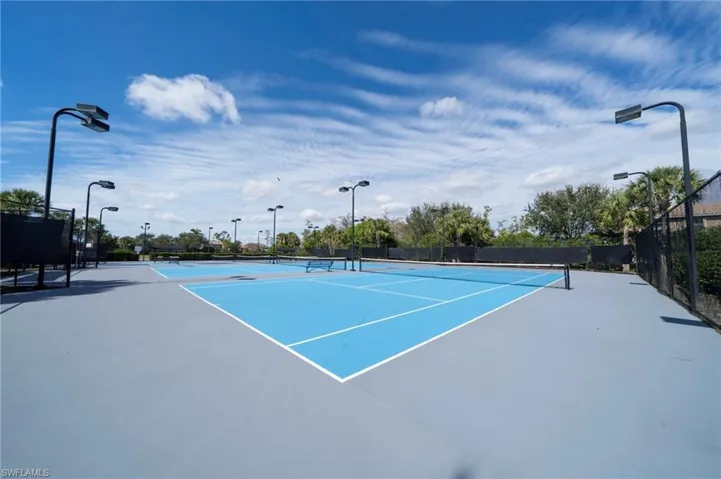 View of tennis court featuring a patio area