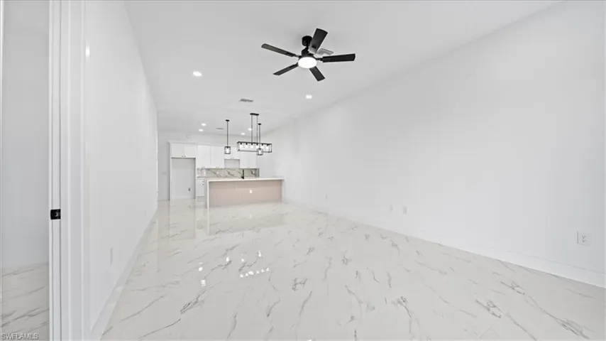 Unfurnished living room with recessed lighting, ceiling fan, and light marble finish flooring