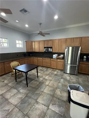 Kitchen with stainless steel appliances, tile flooring, ceiling fan, and crown molding