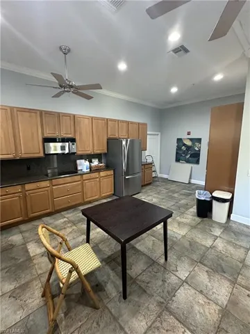 Kitchen featuring ceiling fan, tasteful backsplash, tile floors, ornamental molding, and appliances with stainless steel finishes