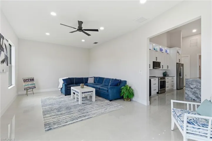 Living room featuring ceiling fan, recessed lighting and ample natural light