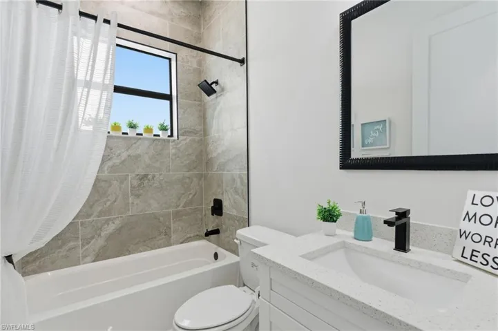 Guest bathroom featuring shower / bath combo, linen closet and vanity