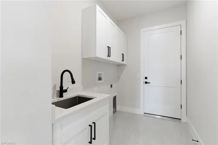 Laundry room featuring sink, cabinet space, electric dryer hookup, and hookup for a washing machine