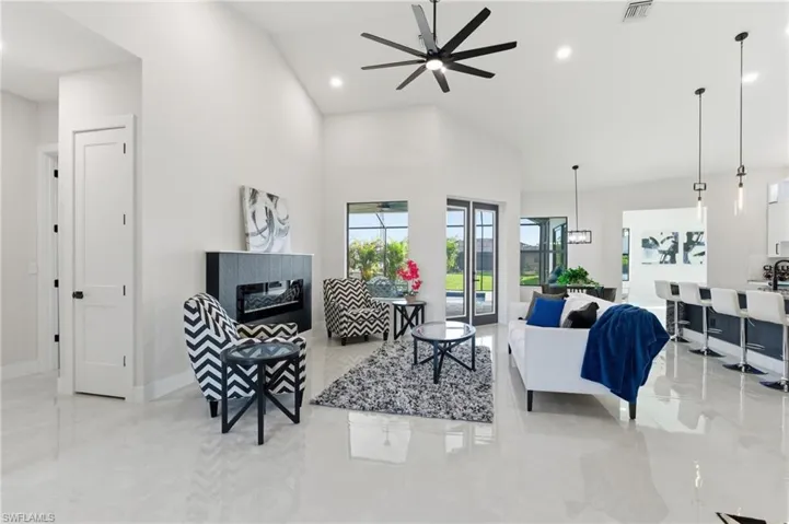 Living area featuring ceiling fan, recessed lighting, a tile fireplace, and vaulted ceiling