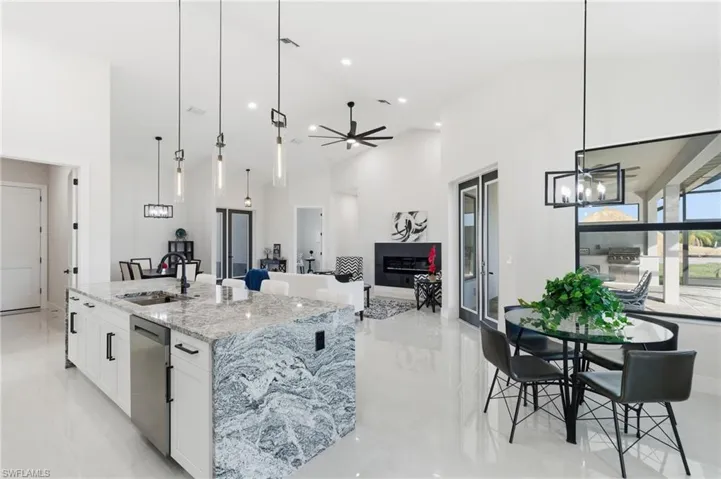 Kitchen featuring ceiling fan, premium counters, white cabinetry and a spacious island