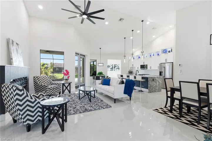 Living room featuring a ceiling fan, recessed lighting, and vaulted ceiling