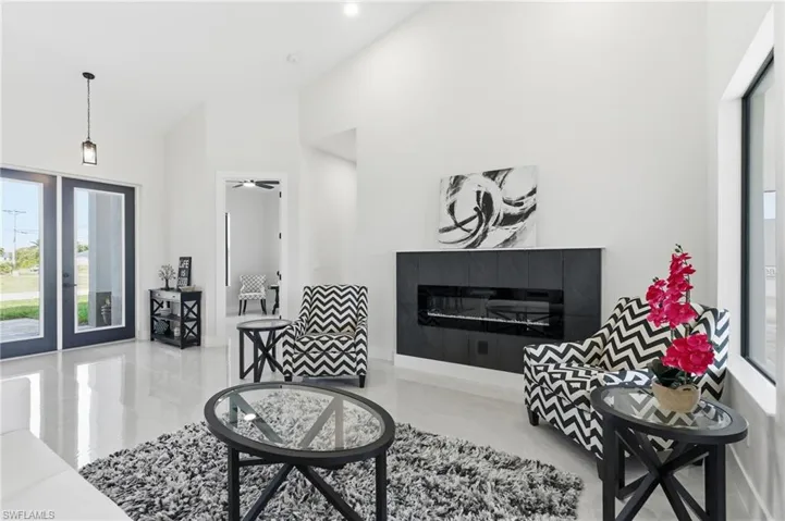 Living area featuring a tiled electric fireplace and vaulted ceiling