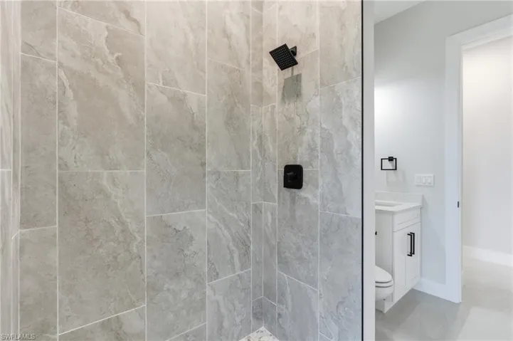 Pool bathroom with vanity and tiled shower