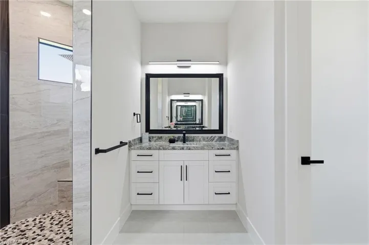 Primary bathroom with two vanities and a walk in shower