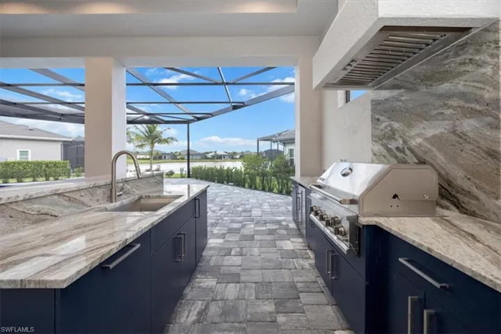 View of patio / terrace with exterior kitchen, a sunroom, a lanai, and a residential view