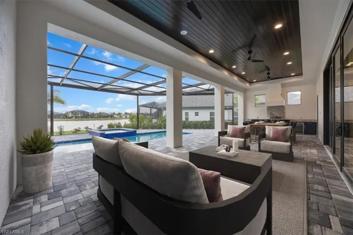 View of patio / terrace with an outdoor living space, a water view, a lanai, ceiling fan, and a pool with connected hot tub