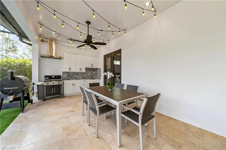 View of patio with an outdoor kitchen / dining area and ceiling fan