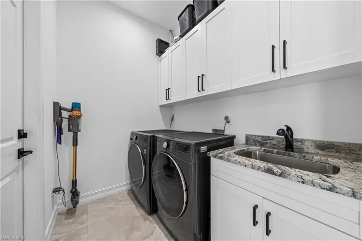 Laundry area with cabinet space and washer and clothes dryer