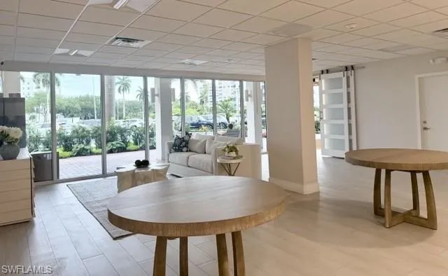 Expansive interior space featuring light wood-finish flooring and a white grid ceiling