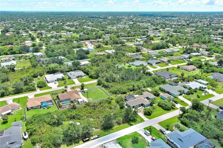 Aerial view of property and surrounding area featuring nearby suburban area