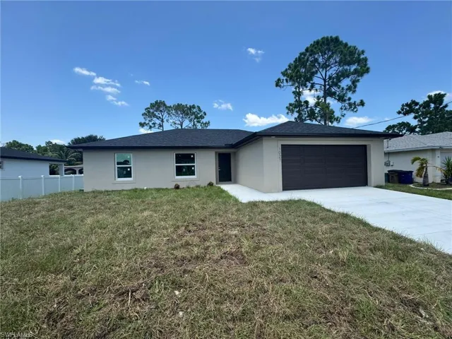 Ranch-style home featuring stucco siding, an attached garage, and driveway