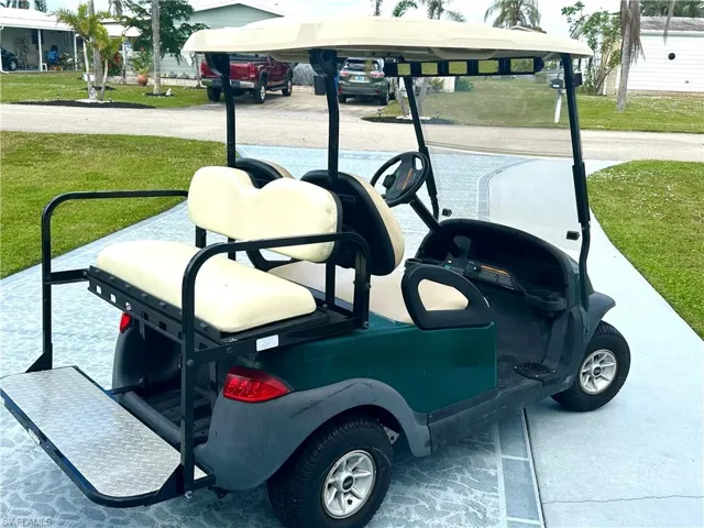 Back/side view of four seat golf cart included in full price sale of home.