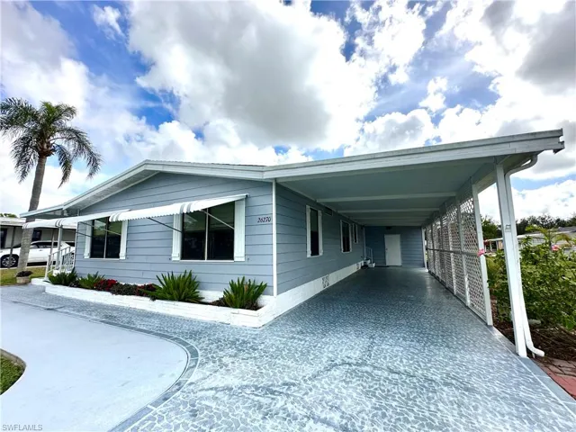 Front of home, painted driveway, and carport.