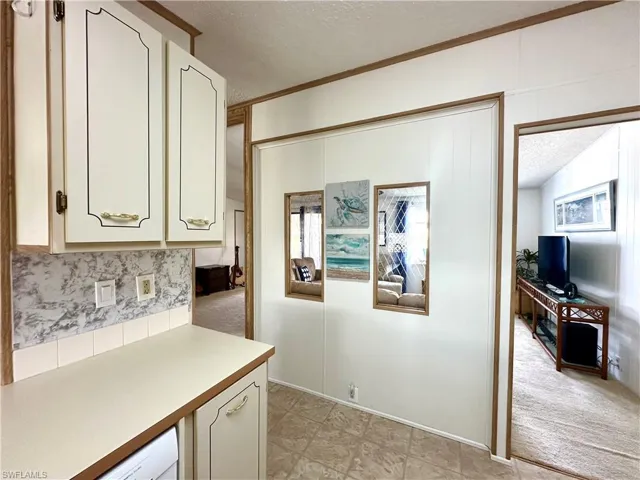 The walkway between the kitchen and living room, featuring transom windows.