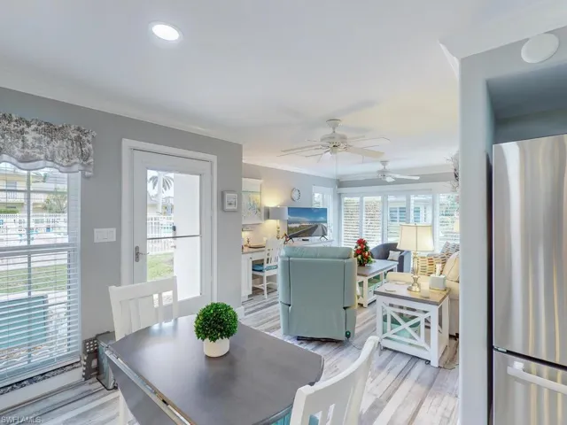 Dining space with ceiling fan, crown molding, and light wood-type flooring