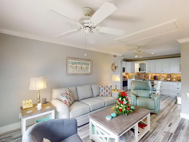 Living room with crown molding, light hardwood / wood-style flooring, and ceiling fan