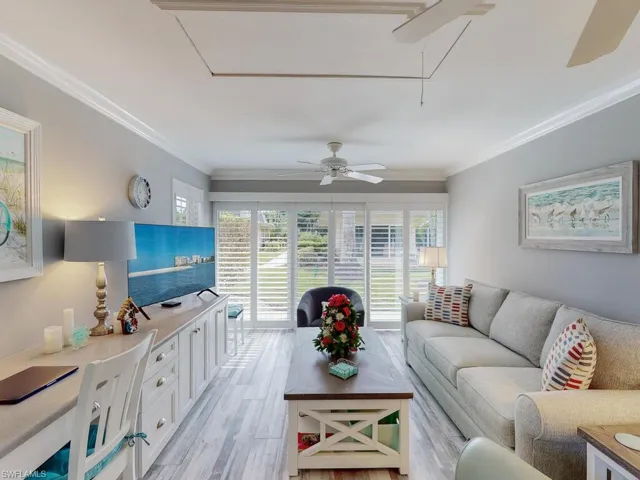 Living room with a healthy amount of sunlight, light hardwood / wood-style flooring, ceiling fan, and ornamental molding