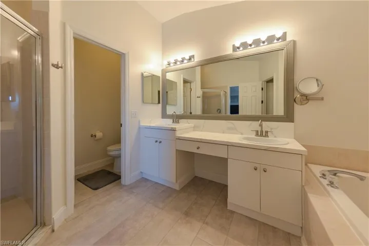 Full bathroom featuring hardwood / wood-style floors, vanity, toilet, and plus walk in shower
