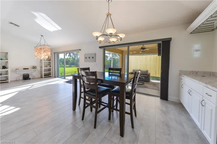 Dining space featuring light hardwood / wood-style floors and ceiling fan with notable chandelier