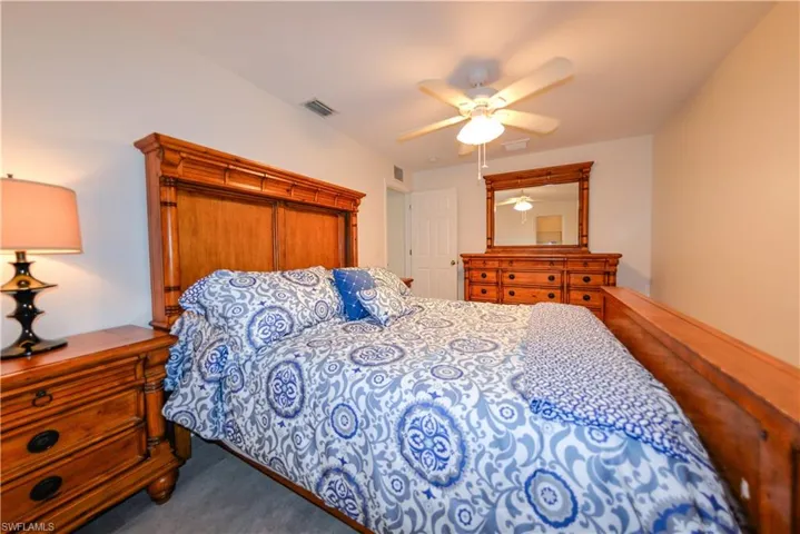 Carpeted bedroom featuring ceiling fan