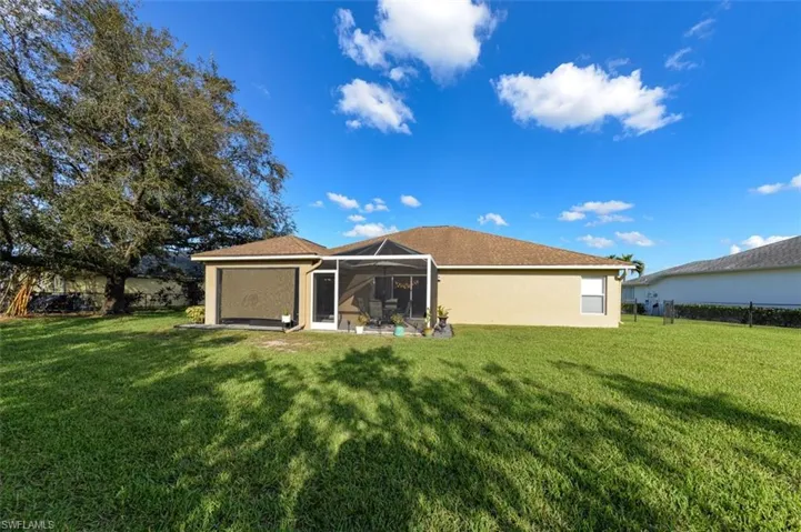 Rear view of house featuring a lawn