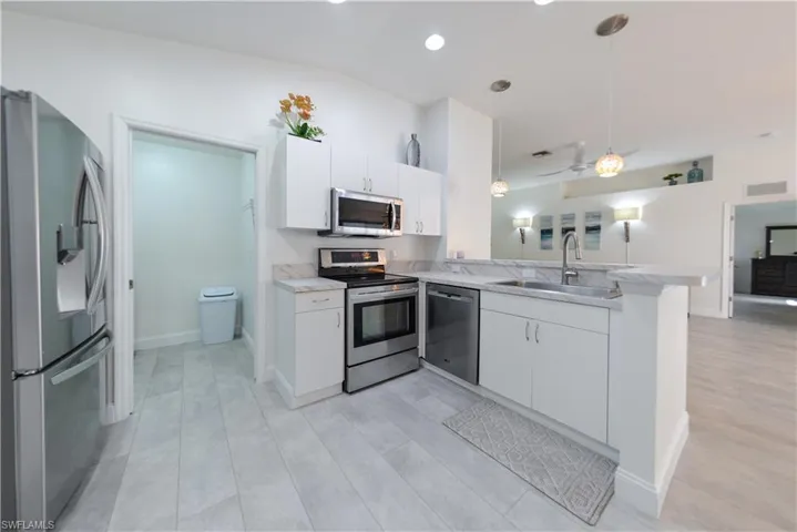 Kitchen featuring white cabinetry, appliances with stainless steel finishes, and sink