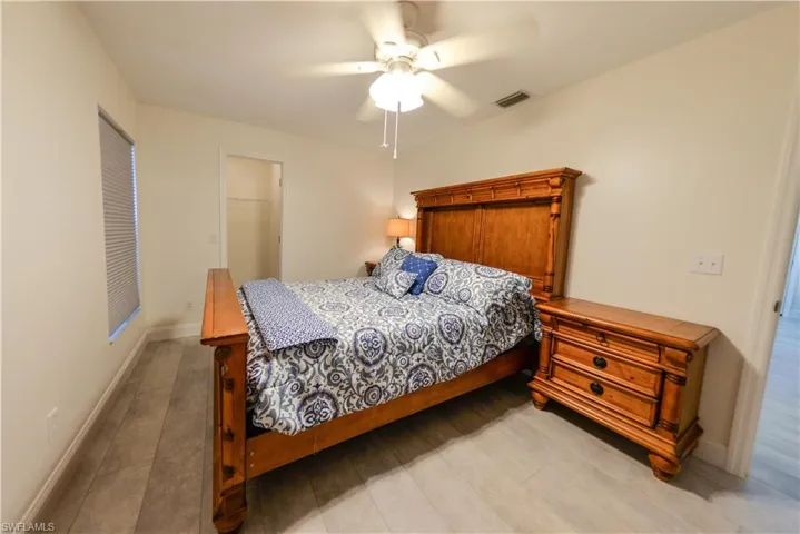 Bedroom with light hardwood / wood-style floors, ceiling fan, a closet, and a walk in closet