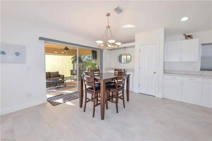 Dining space with ceiling fan with notable chandelier