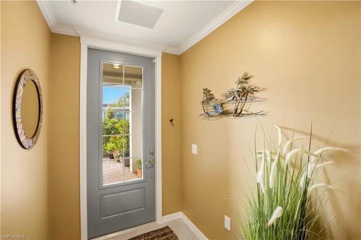 Entryway with baseboards and crown molding