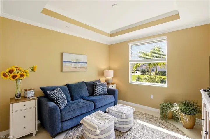 Den featuring crown molding and a raised ceiling