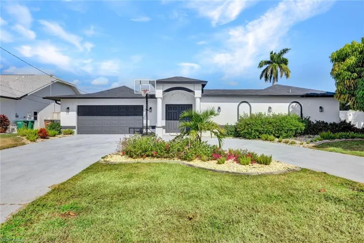 Single story home featuring driveway, stucco siding, a garage, and a front lawn