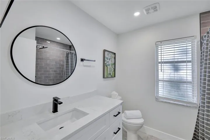 Bathroom with vanity, recessed lighting, light tile patterned flooring, and a tile shower