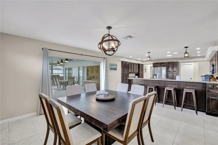 Dining room with light tile patterned floors, a chandelier, and recessed lighting